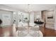 Bright dining area with a modern chandelier, seating for four, and an open floor plan leading to the living room at 912 Ambergate Sta, Apex, NC 27502