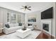 Cozy living room featuring a fireplace, large windows, and stylish furniture, perfect for relaxing and entertaining at 912 Ambergate Sta, Apex, NC 27502