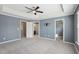 Spacious main bedroom with tray ceiling, carpet floors, ceiling fan and multiple doors at 912 Ambergate Sta, Apex, NC 27502