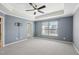 Spacious main bedroom with tray ceiling, ceiling fan, carpet floors and large window at 912 Ambergate Sta, Apex, NC 27502