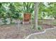 Backyard boasts a climbing wall, disc golf basket, mature tree, and stone-lined landscaping, ideal for outdoor activities at 915 S State St, Raleigh, NC 27601