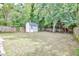 Spacious backyard with a storage shed and a climbing wall, surrounded by lush greenery and a wooden fence at 915 S State St, Raleigh, NC 27601