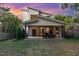 A covered patio with an outdoor seating area, a fireplace, and a lush green backyard at sunset at 915 S State St, Raleigh, NC 27601