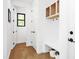 Bright entryway featuring hardwood floors, white walls, storage, bench, and black hardware at 915 S State St, Raleigh, NC 27601