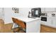 Kitchen island with a sink and seating, complemented by modern appliances and white cabinetry at 915 S State St, Raleigh, NC 27601