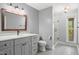 Well-lit bathroom featuring a gray vanity, modern fixtures, and a walk-in shower offering a spa-like experience at 97 Bailey Rd, Coats, NC 27521