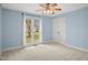Bright bedroom featuring a ceiling fan, closet, blue walls, and lots of natural light at 97 Bailey Rd, Coats, NC 27521