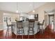Kitchen island with barstool seating, white cabinets, stainless appliances, and hardwood floors at 97 Bailey Rd, Coats, NC 27521
