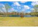 Scenic view of the pond surrounded by trees and a brown horse grazing on the green grass at 97 Bailey Rd, Coats, NC 27521