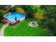 Aerial view of a backyard featuring an above-ground pool, deck, and fire pit at 10 Sapphire Dr, Sanford, NC 27332