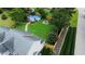 Aerial view of a backyard featuring a pool, fire pit, lush green grass, and a well-maintained wooden fence at 10 Sapphire Dr, Sanford, NC 27332