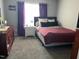 Bedroom with neutral walls, a window with purple curtains, and a red bed at 10 Sapphire Dr, Sanford, NC 27332