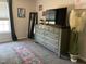 Carpeted bedroom with modern dresser and mirror, featuring a plush area rug at 10 Sapphire Dr, Sanford, NC 27332