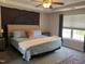 Spacious bedroom featuring a tray ceiling, a ceiling fan, and a large sunny window at 10 Sapphire Dr, Sanford, NC 27332