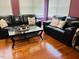 Bright and airy sitting room features dark leather sofas and a glass coffee table at 10 Sapphire Dr, Sanford, NC 27332