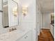 Stylish bathroom with marble countertops, designer lighting, and hardwood floors leading to the hallway at 104 Perth Ct, Cary, NC 27511