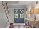 Foyer featuring double doors, brick flooring, staircase, console table and lamps at 104 Perth Ct, Cary, NC 27511
