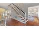 Staircase adjacent to an entry way leading to a light-filled kitchen with brick flooring at 104 Perth Ct, Cary, NC 27511