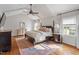 Vaulted main bedroom featuring a four-poster bed, wood floors, a ceiling fan and windows at 104 Perth Ct, Cary, NC 27511