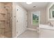 Bathroom with tiled walk-in shower, white vanity and grey floor tile at 1100 Medlin Dr, Cary, NC 27511