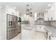 Modern kitchen featuring white cabinets, granite countertops, stainless steel appliances, and tile flooring at 1100 Medlin Dr, Cary, NC 27511