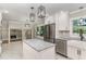 Updated kitchen with white cabinetry, granite island, stainless steel appliances, and open layout at 1100 Medlin Dr, Cary, NC 27511