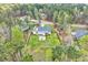An aerial shot showcasing a beautiful home with a fenced-in yard and a charming fire pit area surrounded by lush trees at 1165 Shonele Ln, Stem, NC 27581