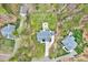 An aerial perspective displays the roof and vast backyard with a firepit, surrounded by green trees and the home's driveway at 1165 Shonele Ln, Stem, NC 27581