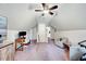 This spacious bonus room features a ceiling fan, sitting area, and dedicated desk space at 1165 Shonele Ln, Stem, NC 27581