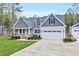 A charming home with a well-manicured lawn, a two-car garage, and an inviting front porch at 1165 Shonele Ln, Stem, NC 27581