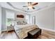 Relaxing main bedroom with tray ceiling, ceiling fan, large bed and cushioned bench at 1165 Shonele Ln, Stem, NC 27581