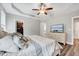 Main bedroom with tray ceiling, ceiling fan, walk-in closet and light colored dresser with TV on top at 1165 Shonele Ln, Stem, NC 27581