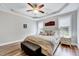 Comfortable main bedroom featuring a tray ceiling, fan, and two large windows at 1165 Shonele Ln, Stem, NC 27581