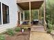 A quaint back porch offers a cozy outdoor space with wood flooring and steps to the landscaped yard at 1200 Roosevelt Dr, Chapel Hill, NC 27514