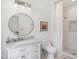 Bright bathroom featuring a white vanity with marble countertop, round mirror, and tiled shower with patterned accents at 1200 Roosevelt Dr, Chapel Hill, NC 27514
