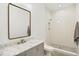 Modern bathroom featuring a gray vanity with marble countertop, rectangular mirror, and tiled shower with built-in niche at 1200 Roosevelt Dr, Chapel Hill, NC 27514