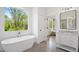 Luxurious bathroom featuring a freestanding tub, marble vanity, and serene outdoor views, creating a spa-like retreat at 1200 Roosevelt Dr, Chapel Hill, NC 27514