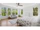 Bright bedroom with many windows offering beautiful outdoor views, ceiling fan, and hardwood floors at 1200 Roosevelt Dr, Chapel Hill, NC 27514