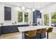 Modern kitchen with navy cabinets, stainless steel appliances, marble countertops, and island with seating for three at 1200 Roosevelt Dr, Chapel Hill, NC 27514