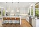 Bright kitchen features a spacious island with seating, stainless appliances, and sleek white cabinetry, perfect for entertaining at 1200 Roosevelt Dr, Chapel Hill, NC 27514