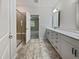 Bathroom boasts a double vanity with white cabinets, tiled floors, and a glass-enclosed shower at 1206 Kafka Dr, Fuquay Varina, NC 27526