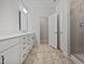 The bathroom features a double vanity with white cabinets, tiled floors, and a glass-enclosed shower at 1206 Kafka Dr, Fuquay Varina, NC 27526