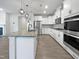 Modern kitchen with white cabinets, stainless steel appliances, granite countertops, and stylish lighting fixtures at 1206 Kafka Dr, Fuquay Varina, NC 27526