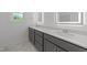 Well-lit bathroom with double vanity, gray cabinets and sleek lighting at 125 Summerlin Dr, Clayton, NC 27527