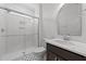 Bathroom with white tiled shower and dark wood vanity, plus a large mirror at 125 Summerlin Dr, Clayton, NC 27527