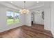 Bright dining room featuring hardwood floors, a modern chandelier, and a large window with a view at 125 Summerlin Dr, Clayton, NC 27527
