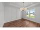 Airy dining room with hardwood floors, a statement chandelier, and large windows showcasing the outdoors at 125 Summerlin Dr, Clayton, NC 27527