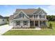 Charming two-story home with gray siding, brown shutters, and a pristine green lawn on a sunny day at 125 Summerlin Dr, Clayton, NC 27527