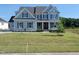 Charming two-story home with light-blue siding, a well-manicured lawn, and a welcoming front porch at 125 Summerlin Dr, Clayton, NC 27527
