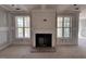 A close-up of a fireplace flanked by large windows, bringing lots of light into the living space at 125 Summerlin Dr, Clayton, NC 27527
